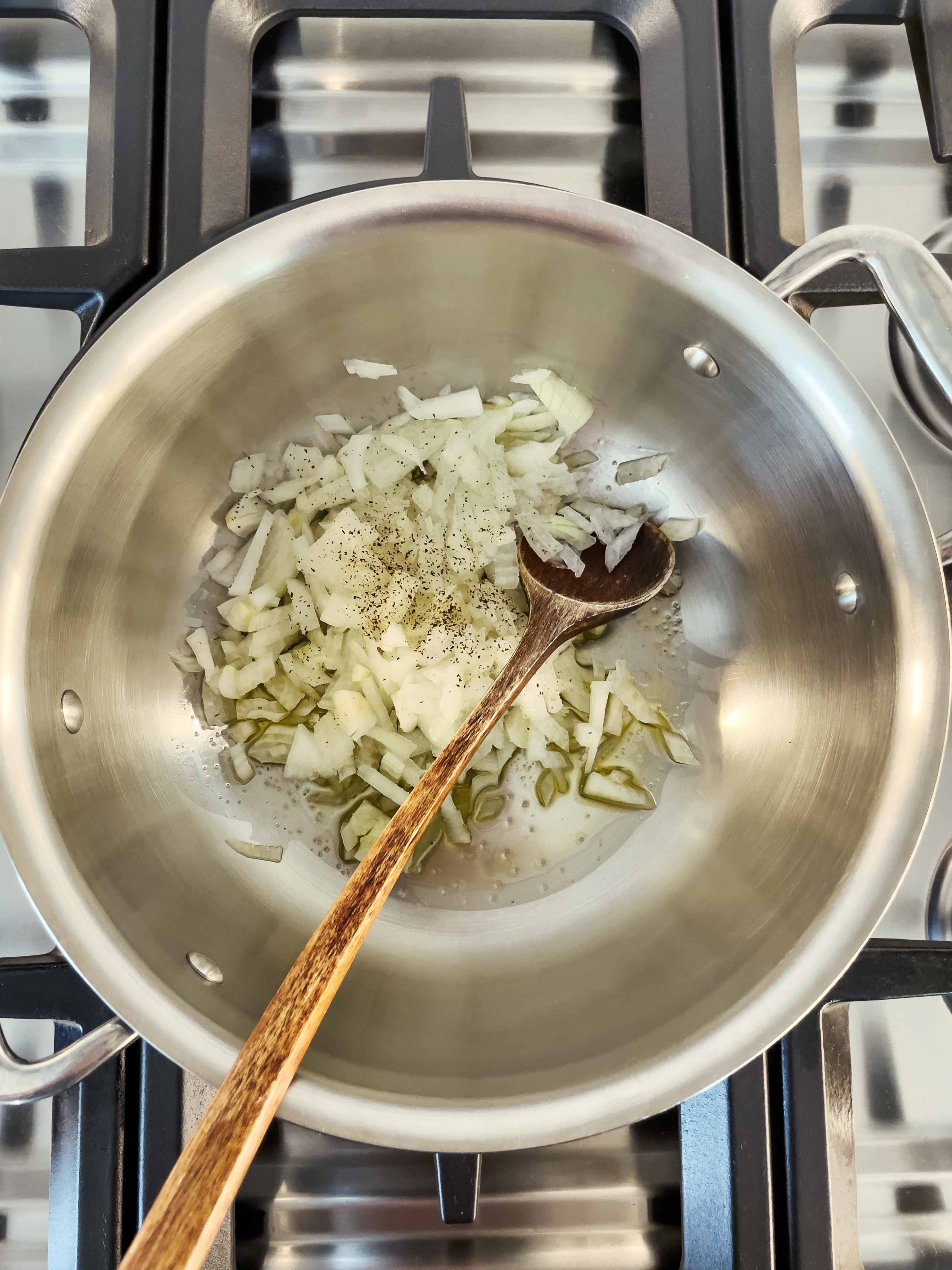 sauteeing onions in a stainless steel pan