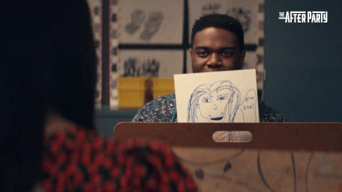 man in an art class holding up his drawing