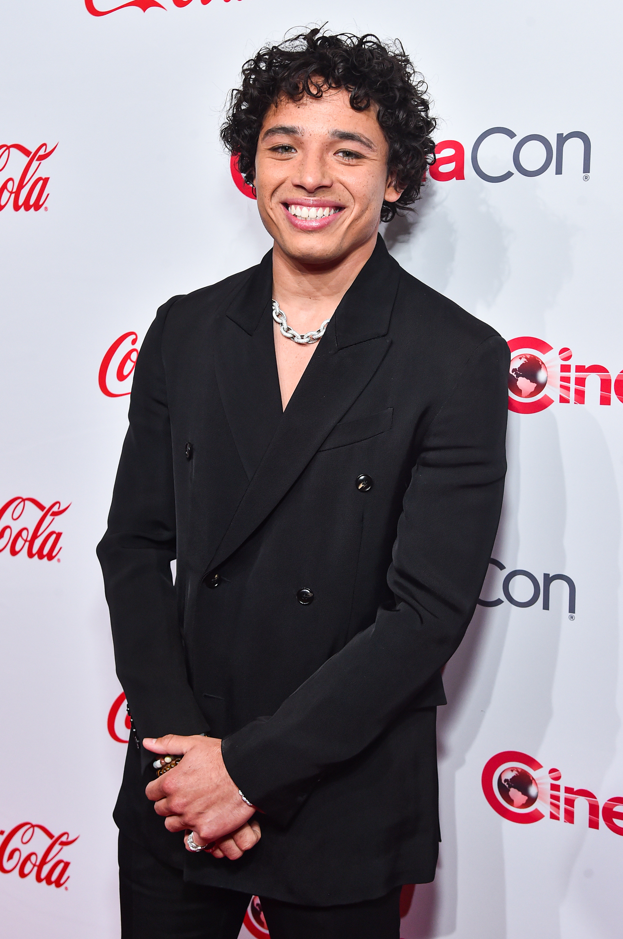 Close-up of Anthony smiling at a media event in a suit