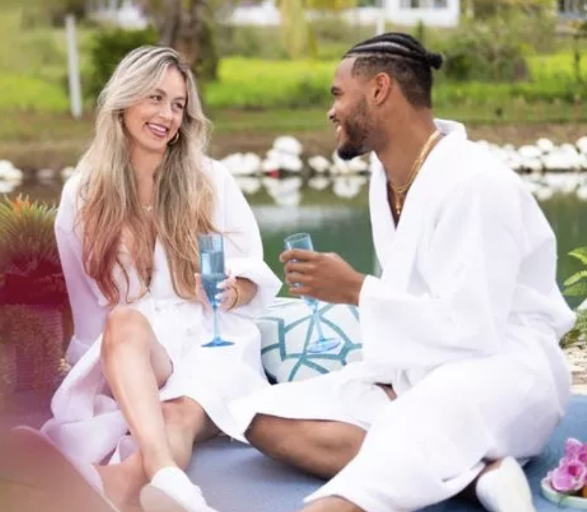 Close-up of Leo and Anna holding drinks and smiling