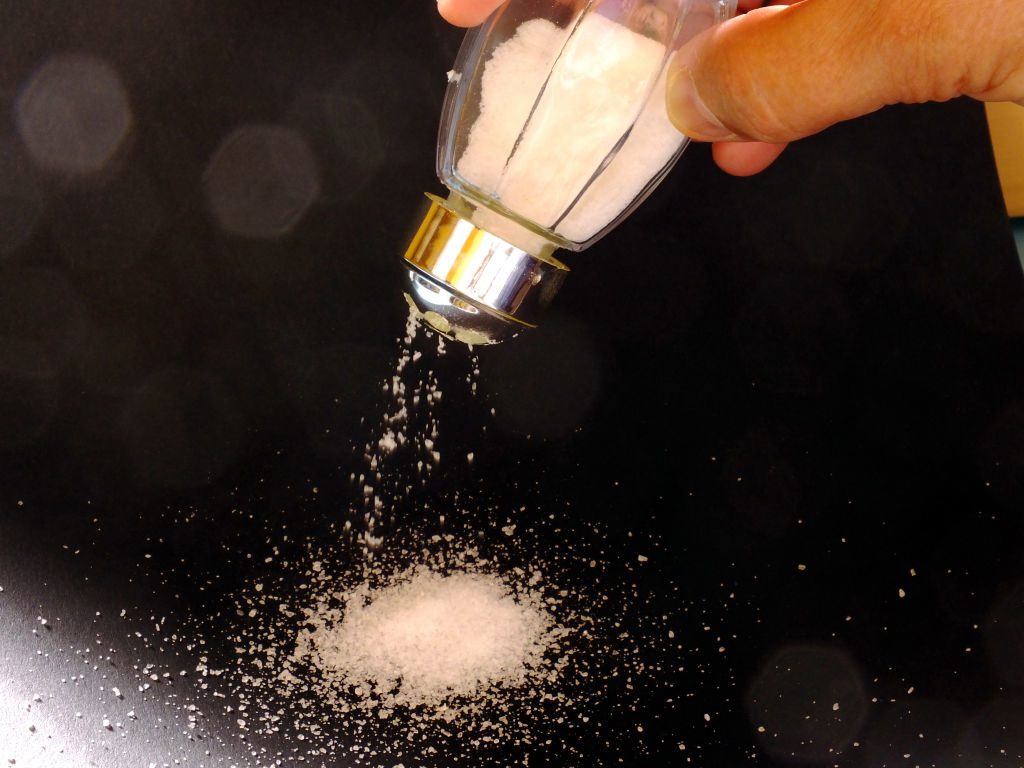 Someone pouring salt on a table