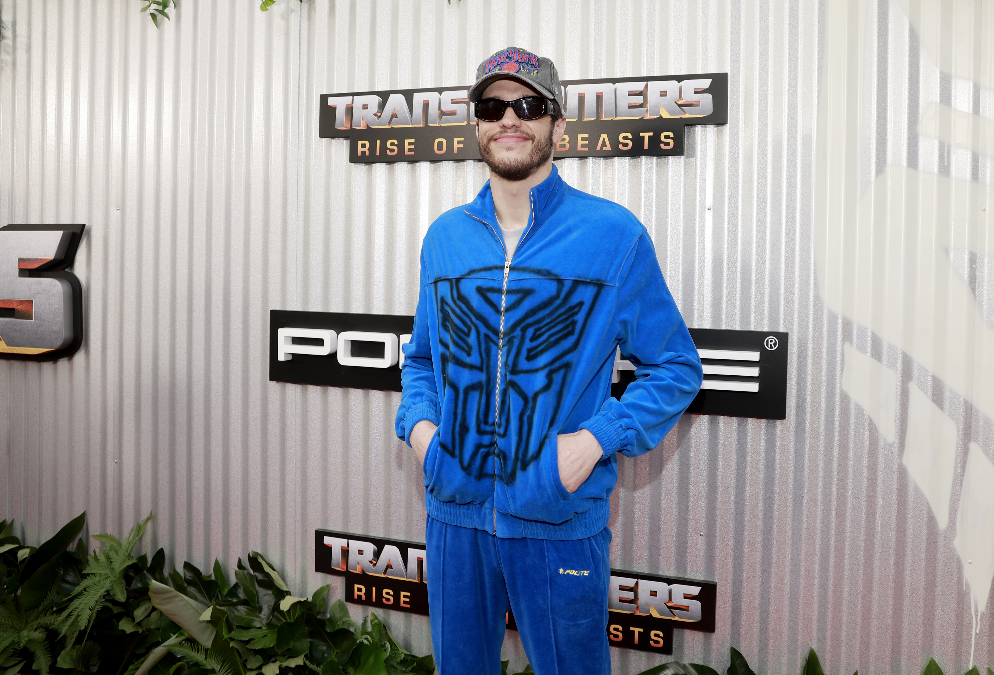 Close-up of Pete at a media event in a tracksuit, sunglasses, and hat