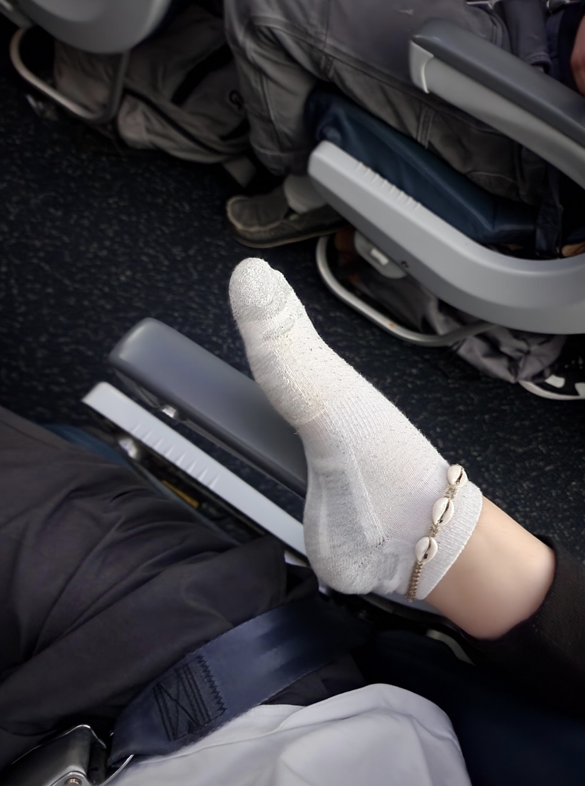 person&#x27;s foot on someone&#x27;s arm rest