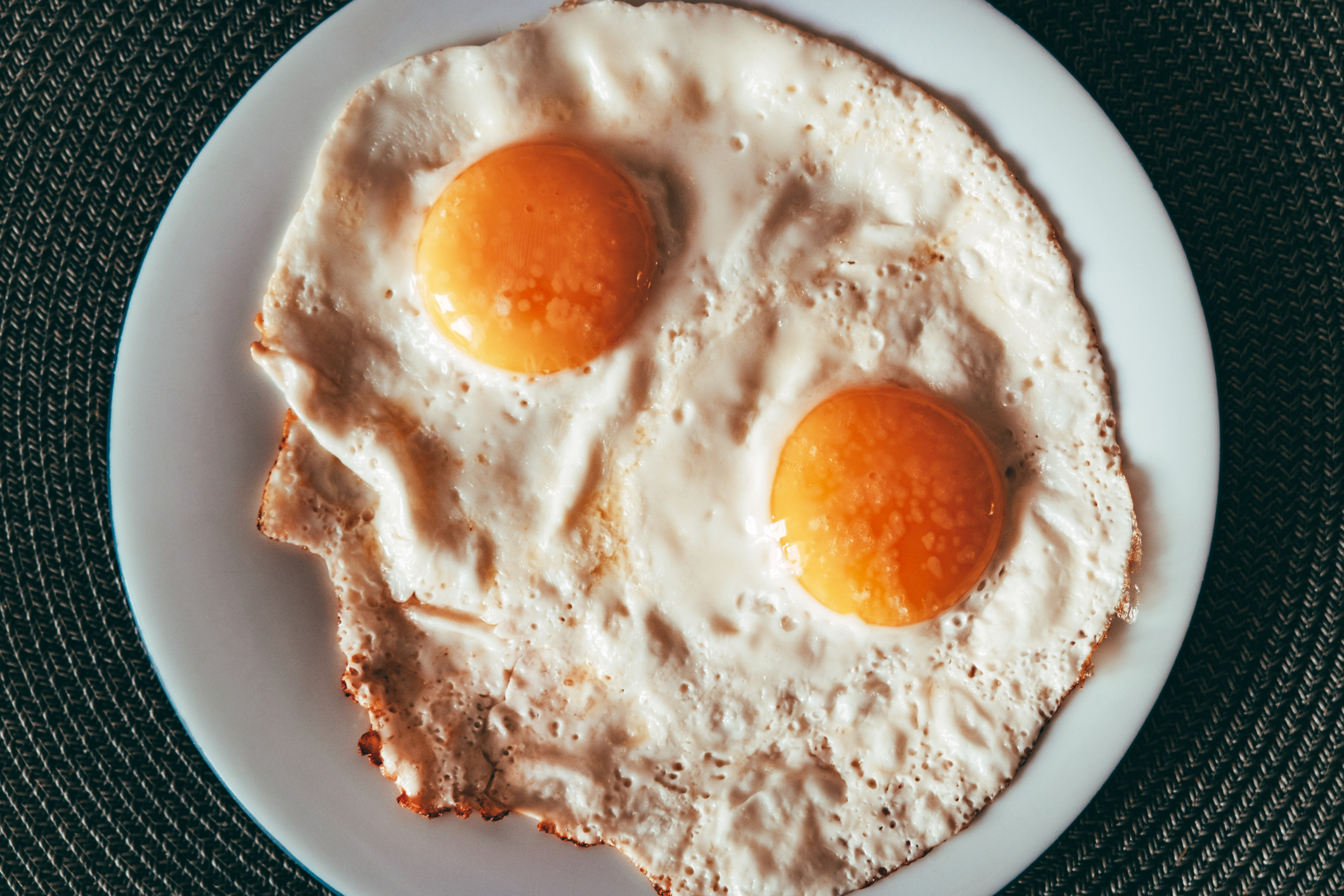 Two sunny-side up eggs on a plate