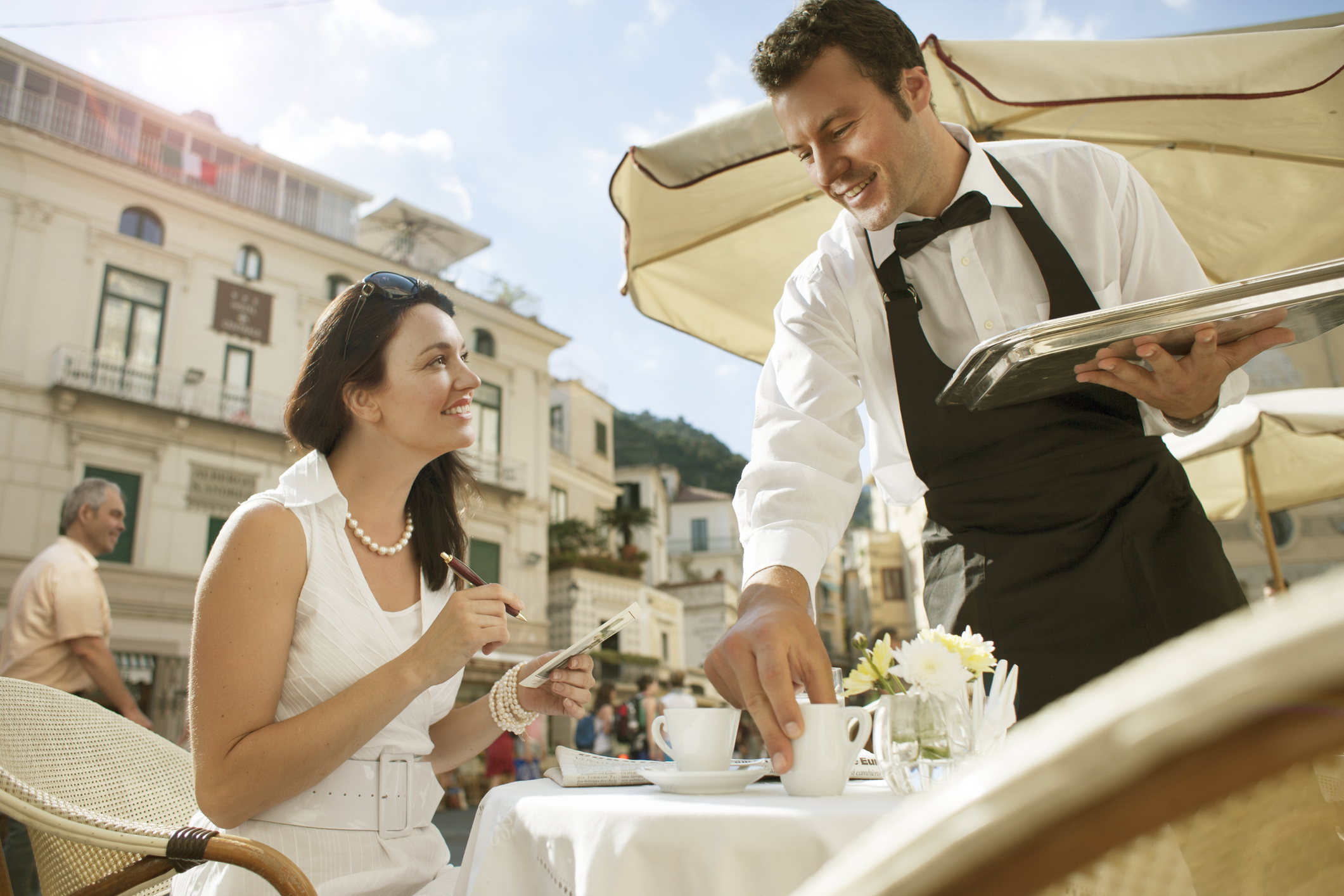 A woman smiling up at a waiter
