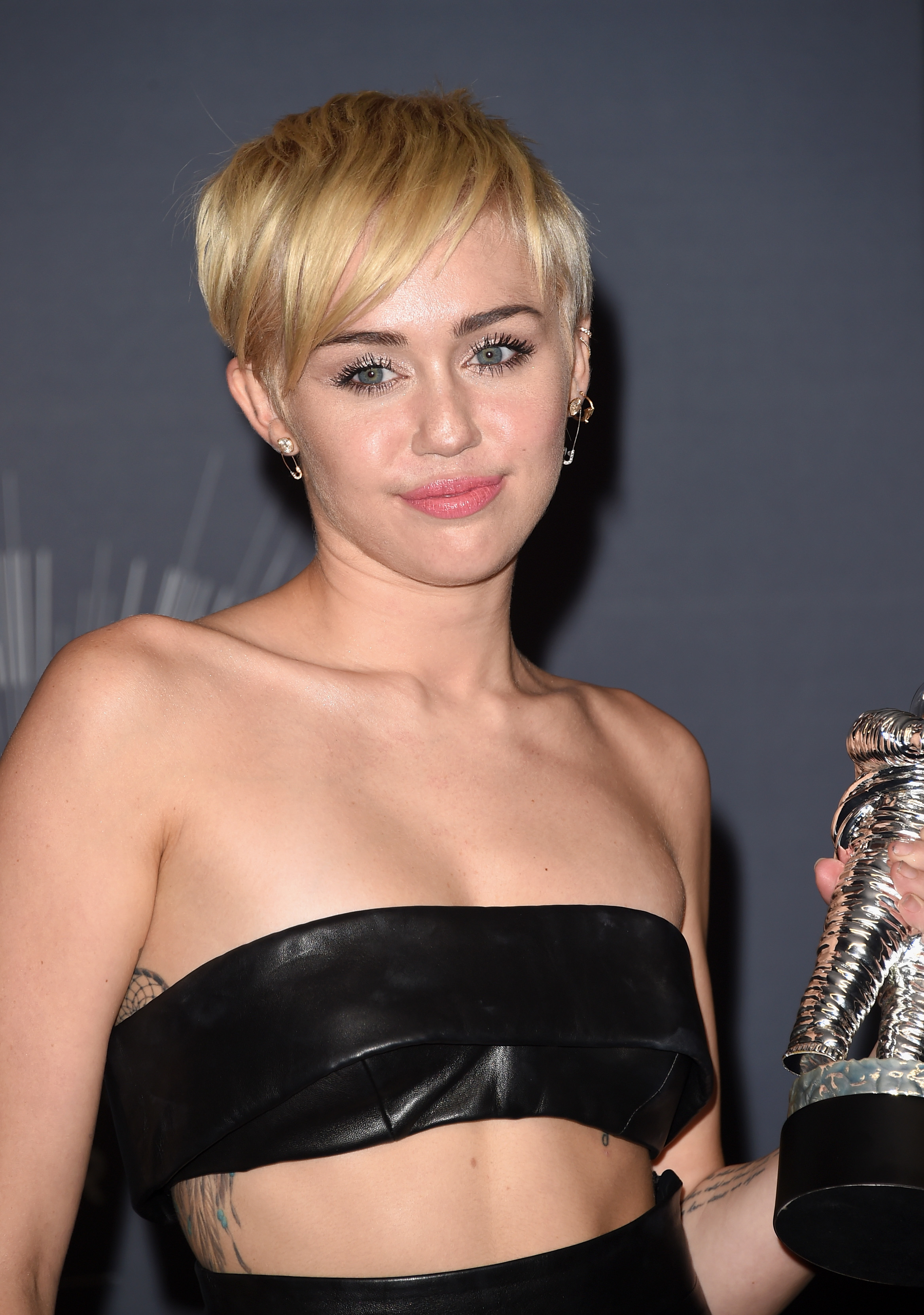 Close-up of Miley holding an award