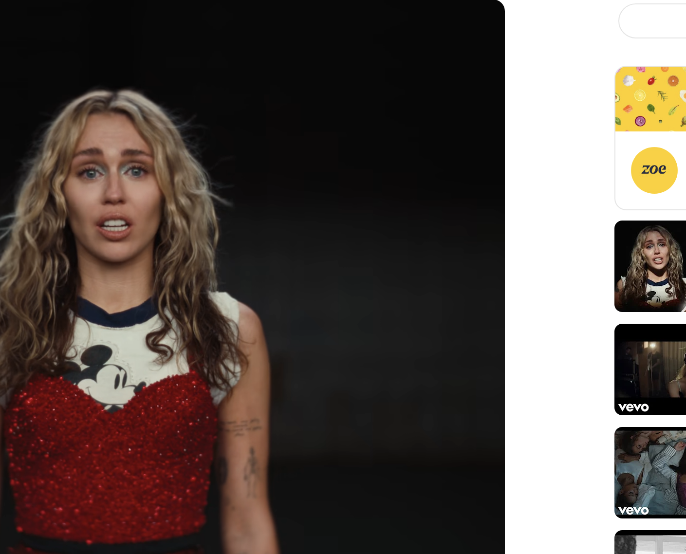 Close-up of Miley from the video, in a sparkly outfit and Mickey Mouse T-shirt