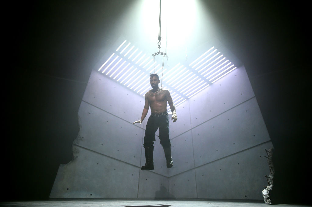 his body hovering over the stage