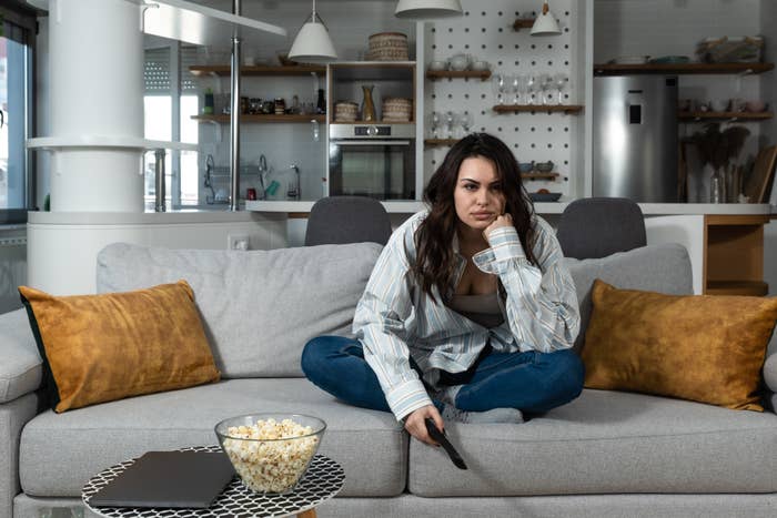 A woman looking disgruntled on her couch