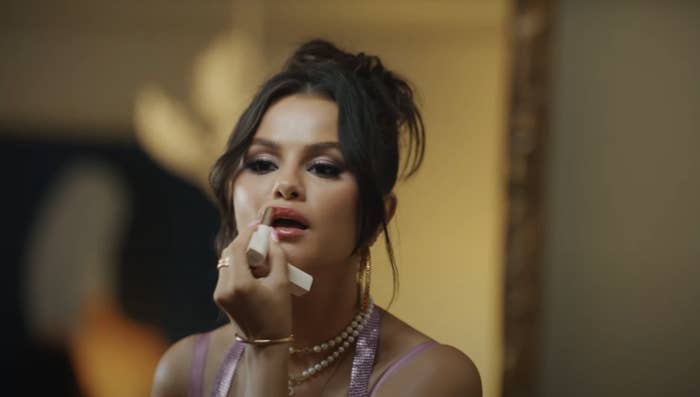 Close-up of Selena putting on lipstick