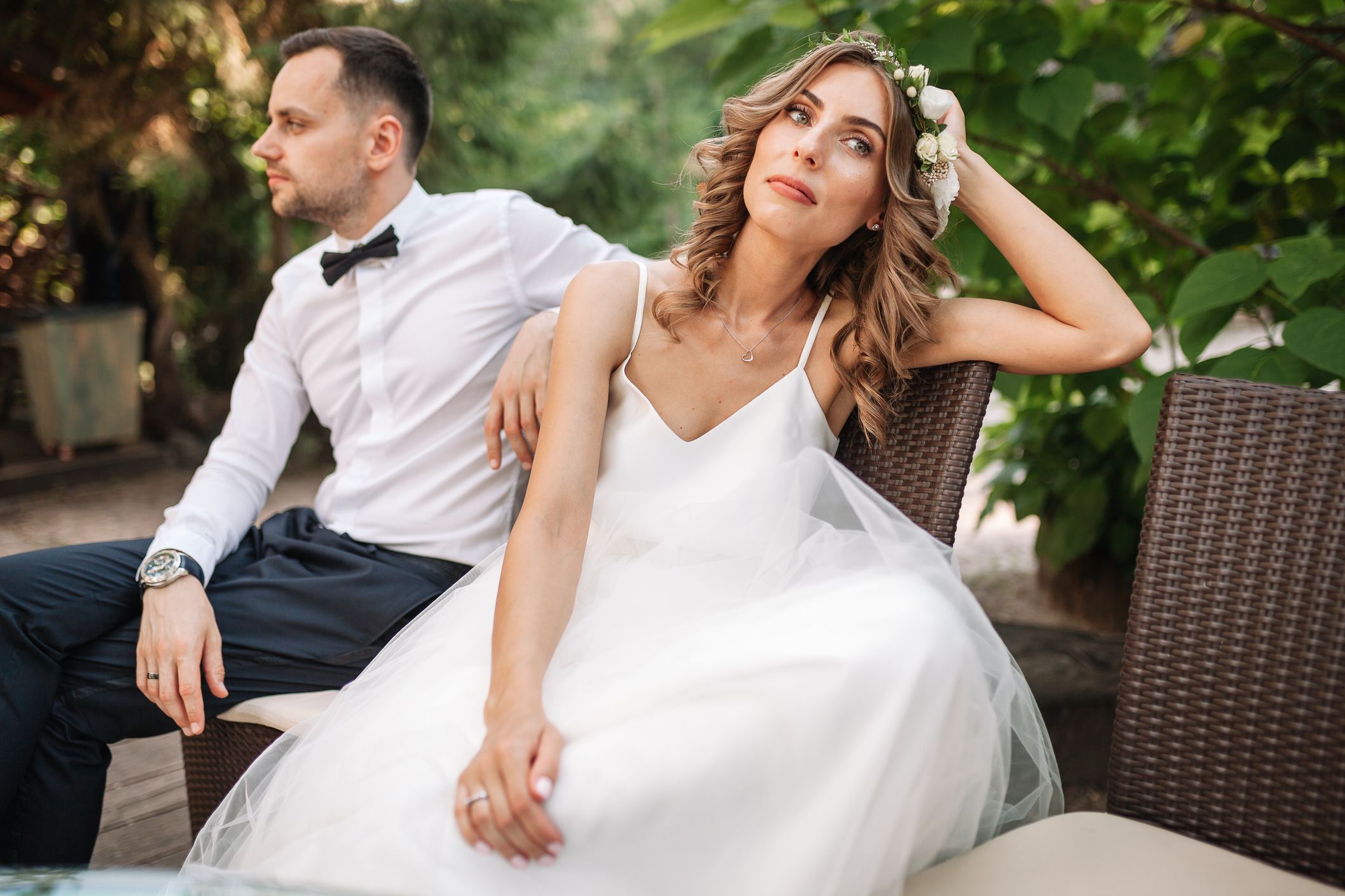 A bride and groom sitting and looking away from each other