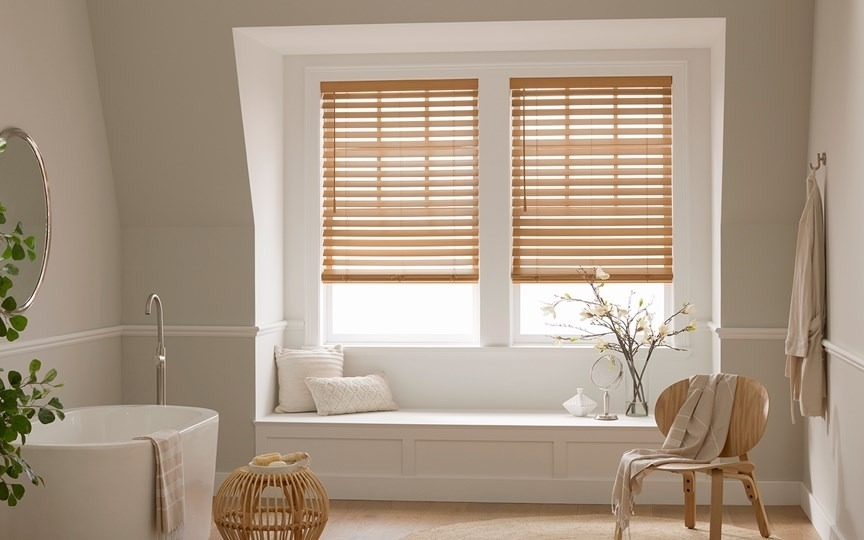 a bathroom with faux wood blinds in the window