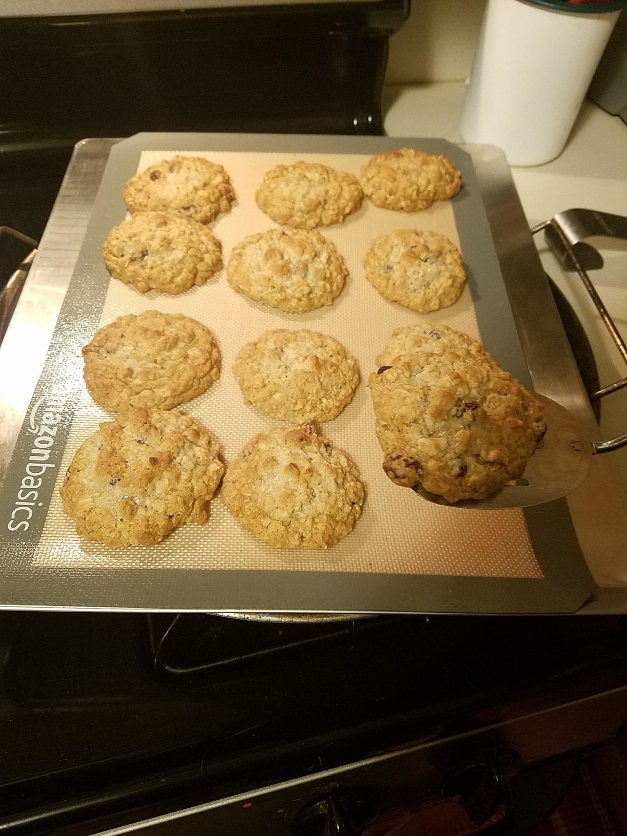 a reviewer photo of a silicone mat on a baking sheet with cookies on it