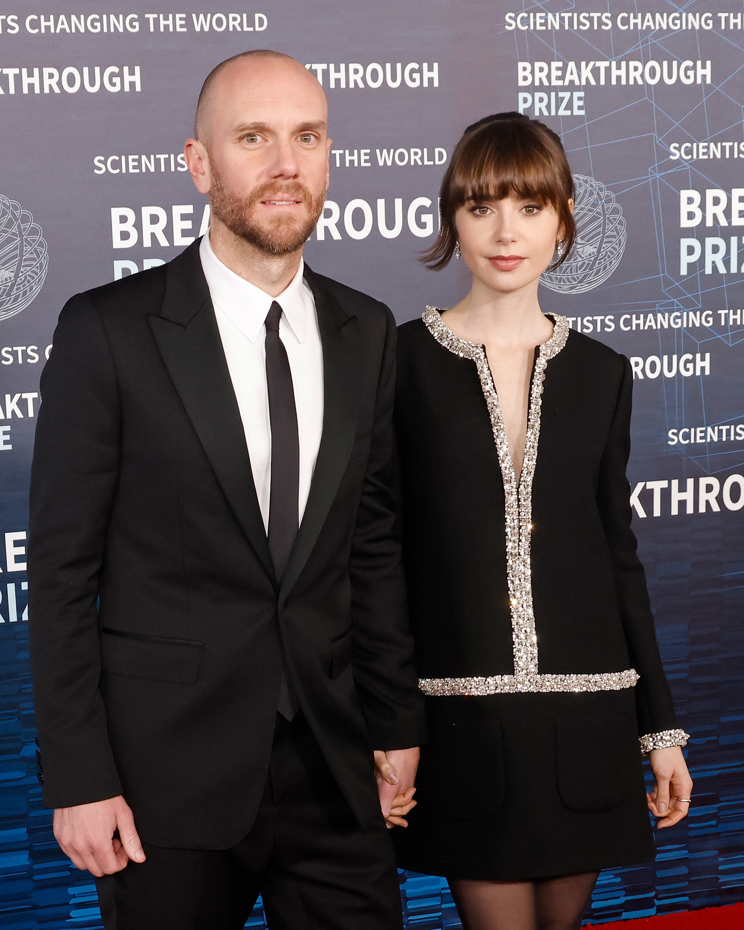 Charlie McDowell and Lily Collins hold hands on the red carpet