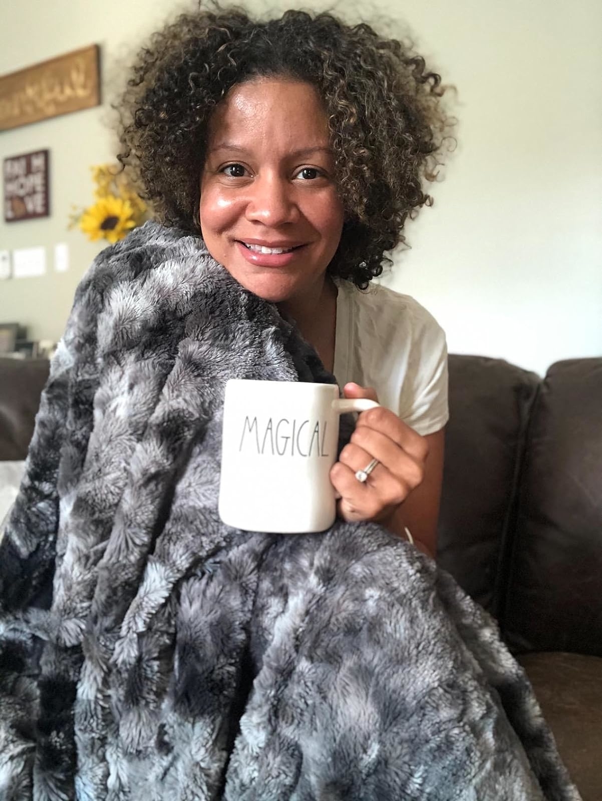 a reviewer wrapped up in the throw blanket in gray