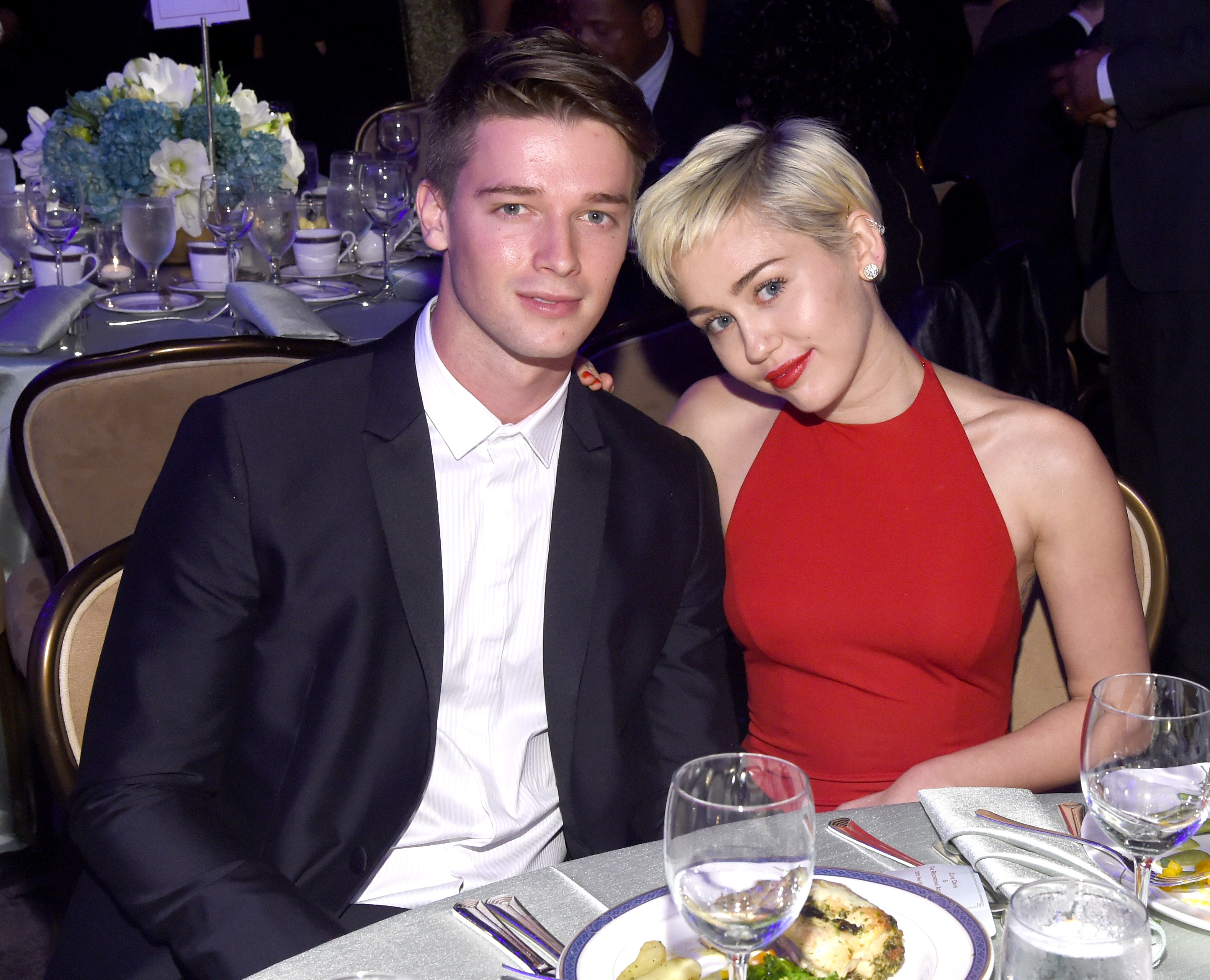 Patrick and Miley sitting at a dinner table at an awards show