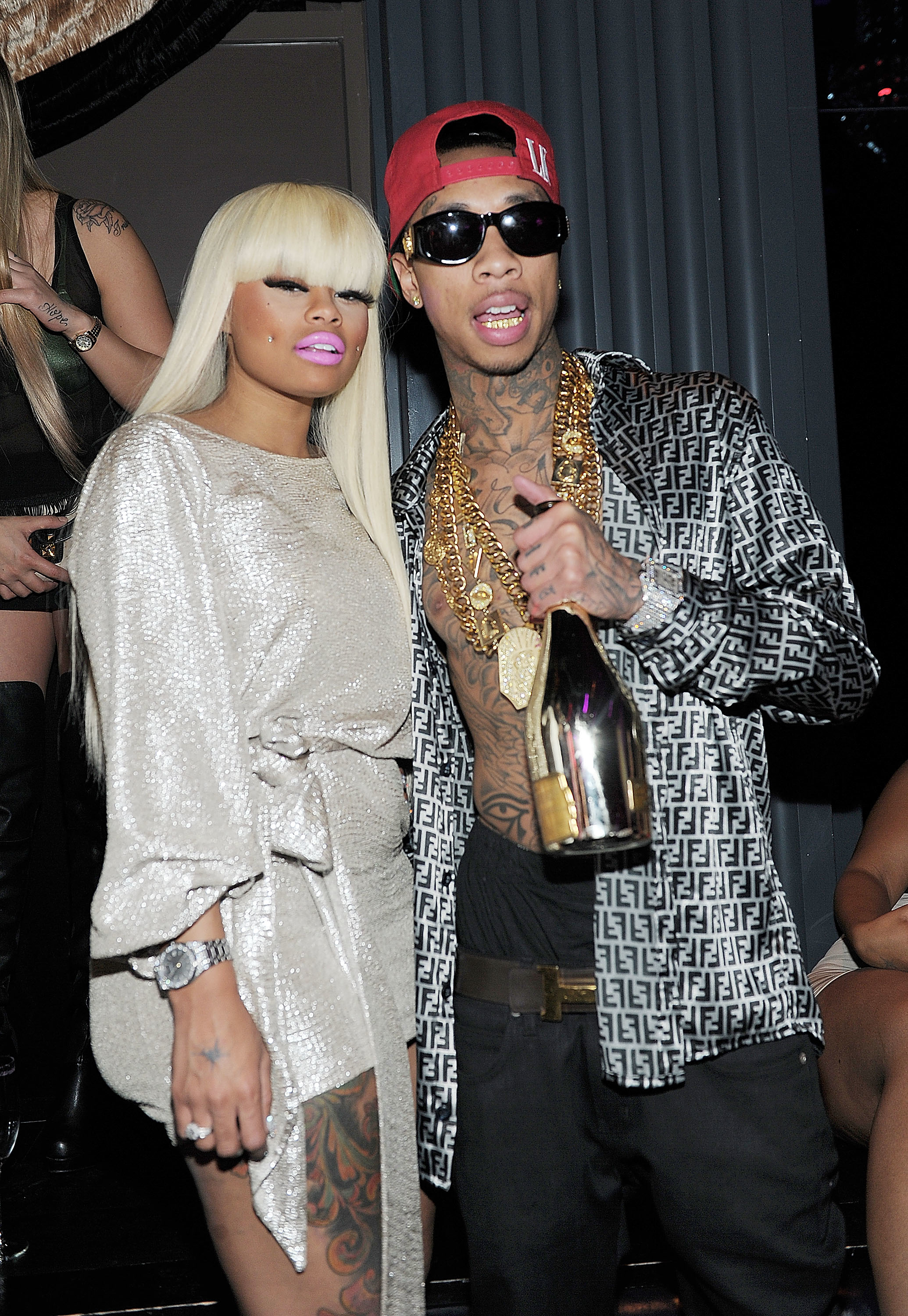 The former couple at an event where Tyga is holding a bottle of champagne