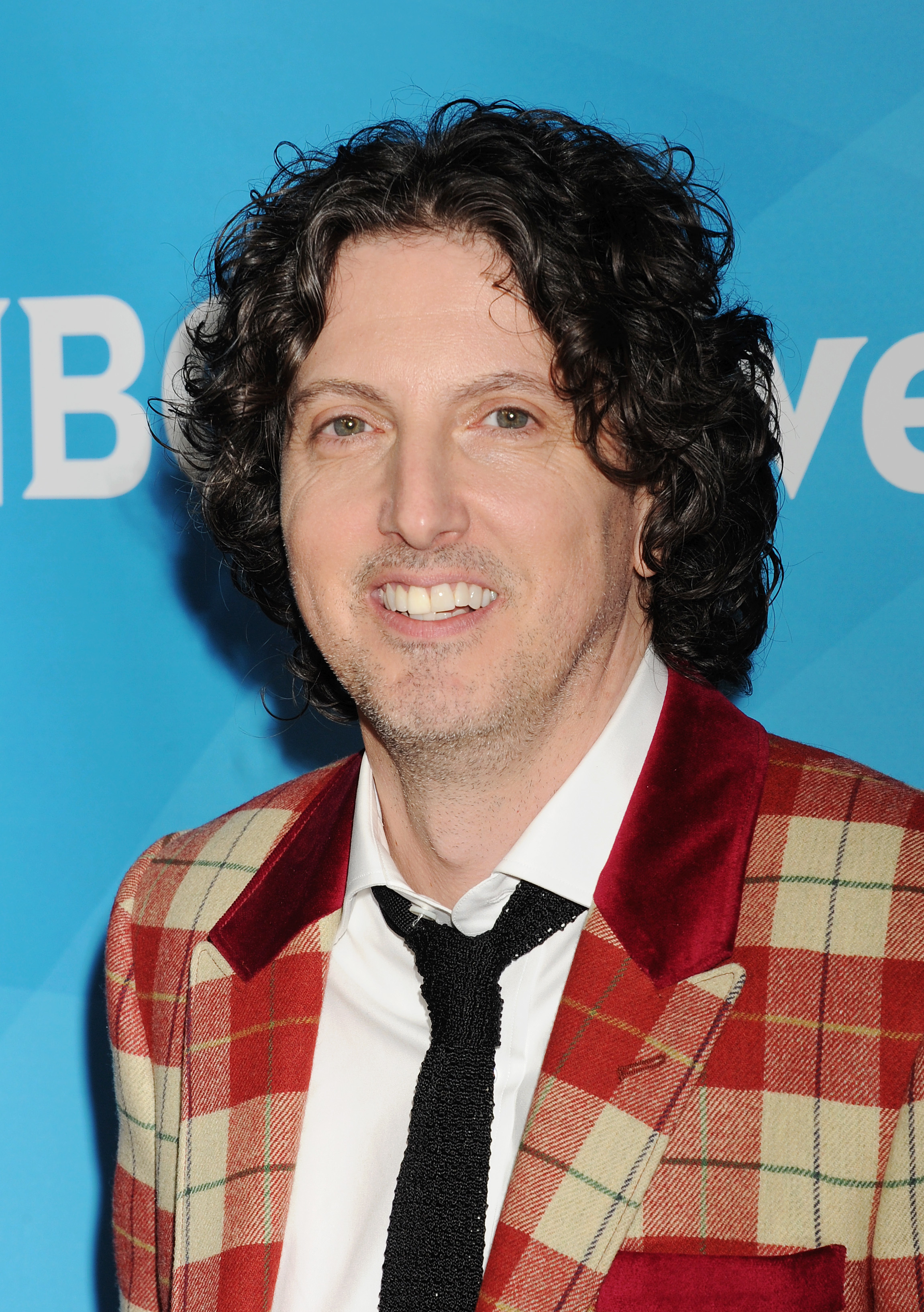 A closeup of Mark Schwahn in a suit