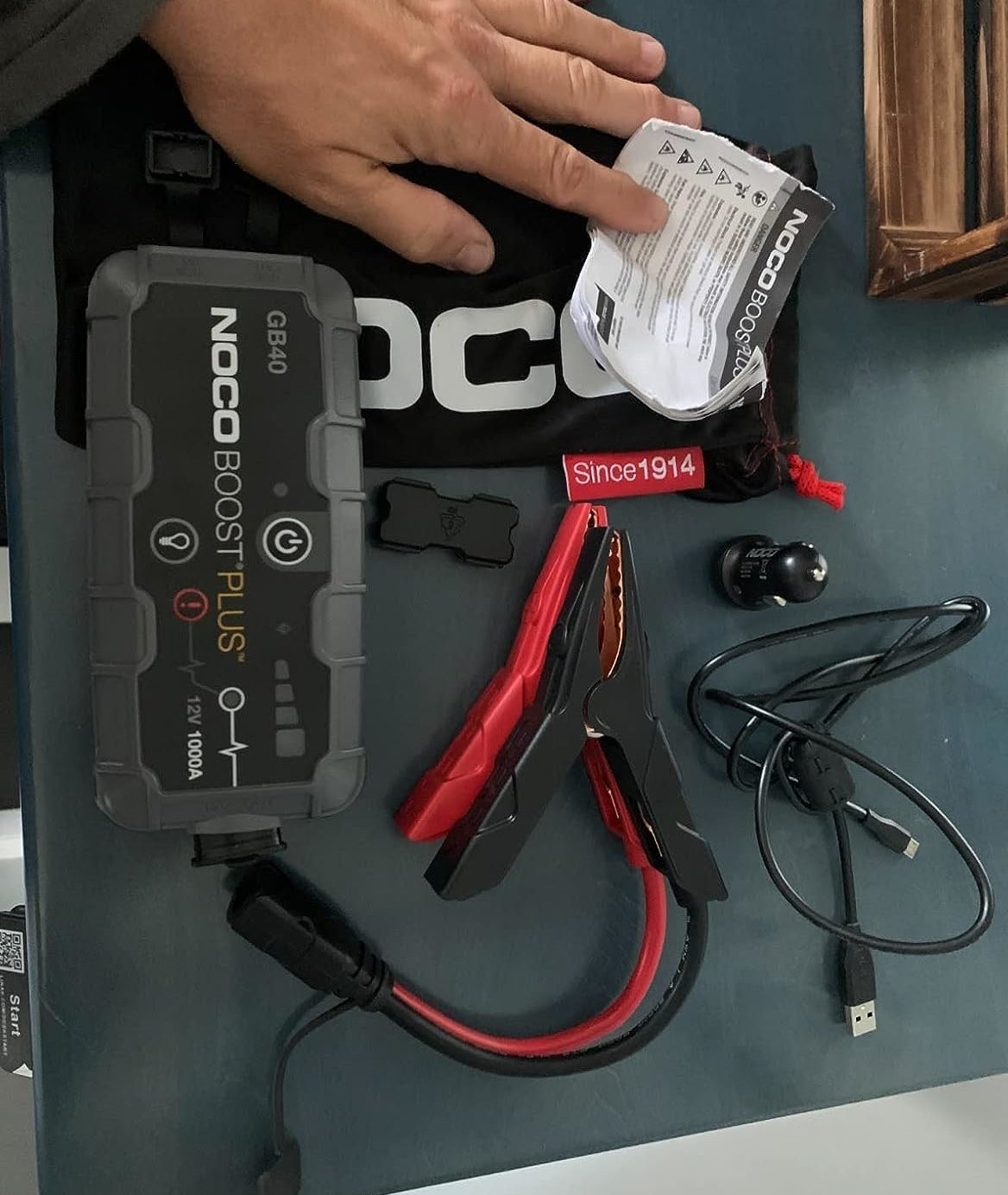 a reviewer photo of the jump starter battery and all the included accessories