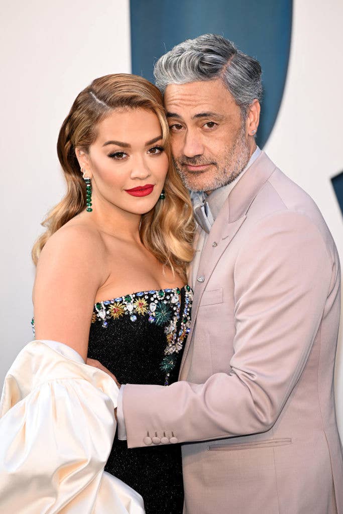 Closeup of Rita Ora and Taika Waititi cuddling at an event