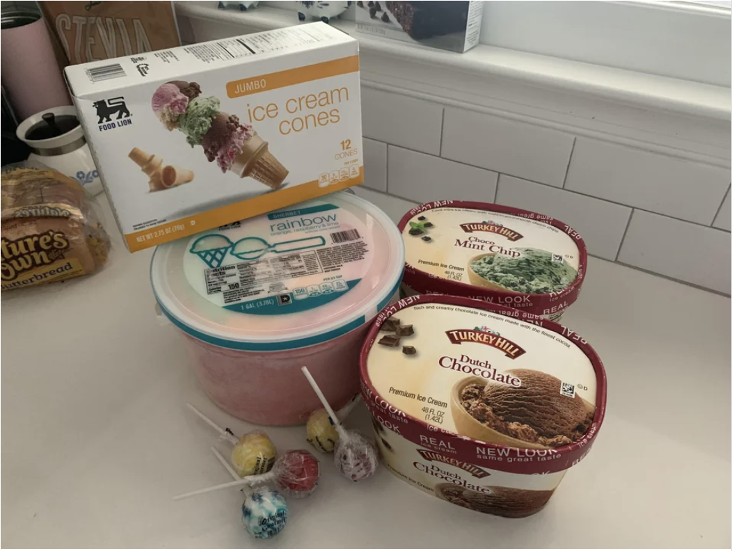 Tubs of ice cream and a box of ice cream cones