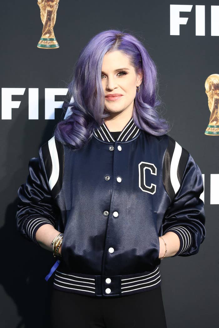 Close-up of Kelly at a media event in a varsity jacket
