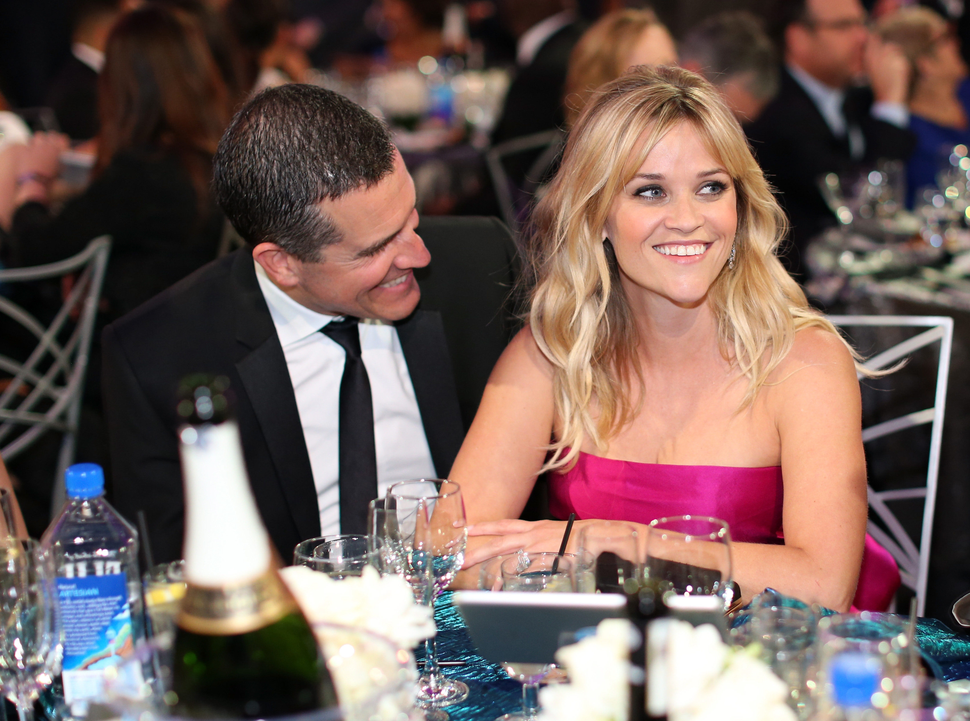 Close-up of Reese and Jim sitting at a table and smiling