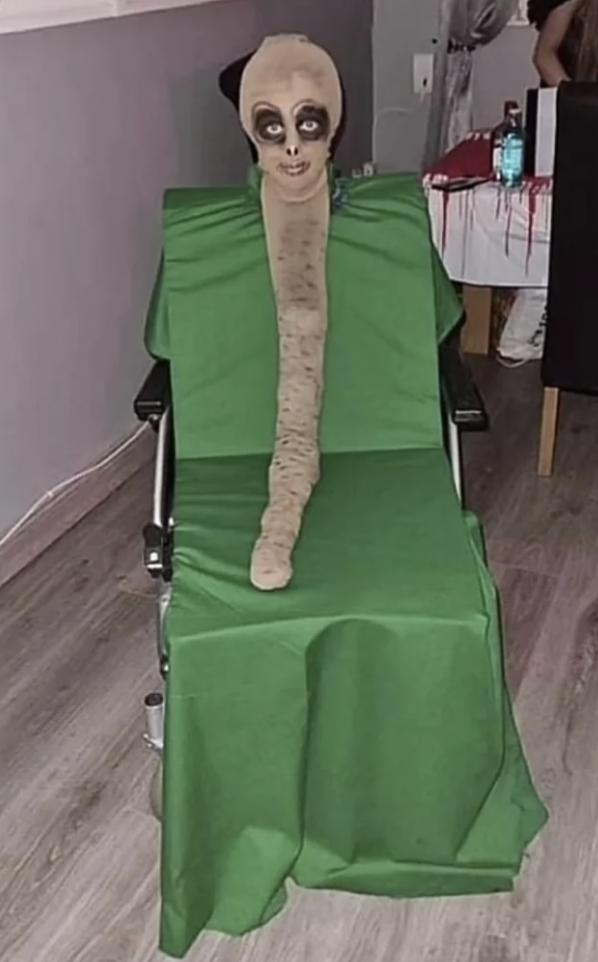 A scary costume on a green sheet on a chair