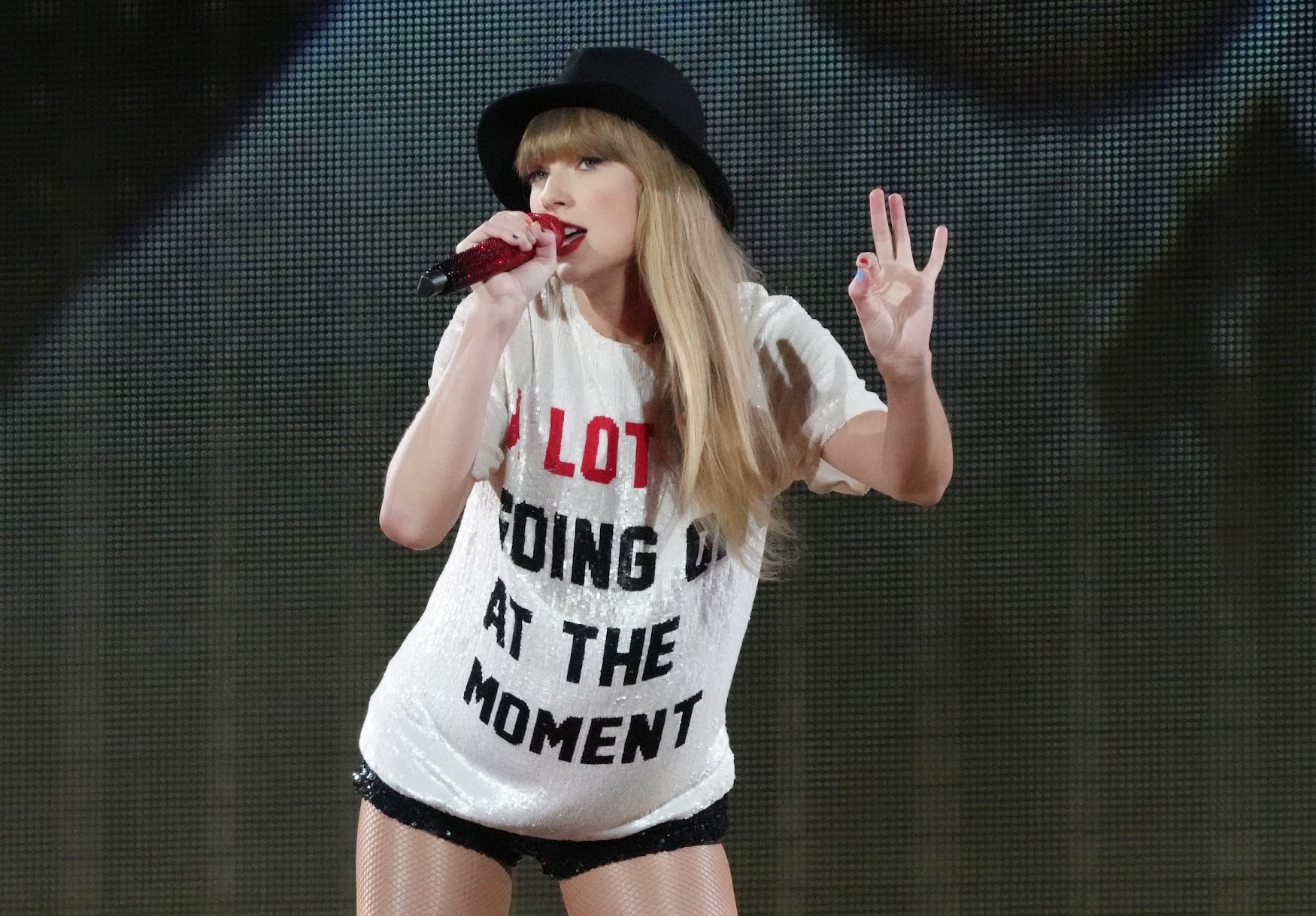 Taylor swift on stage in her 22 outfit
