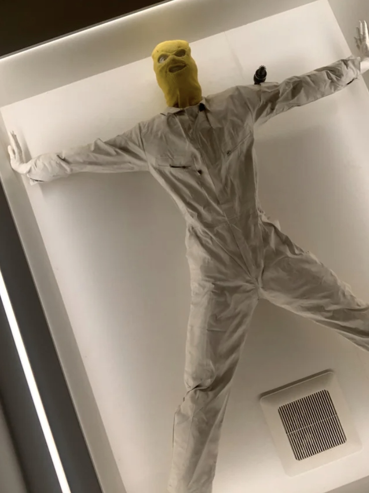 A mannequin in a ski mask and white jumpsuit