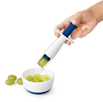 Hand cuts grapes with a grape slicer