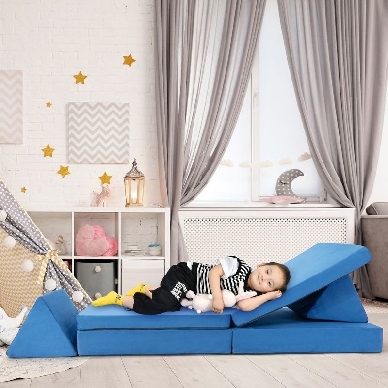 A child model lays on a convertible couch