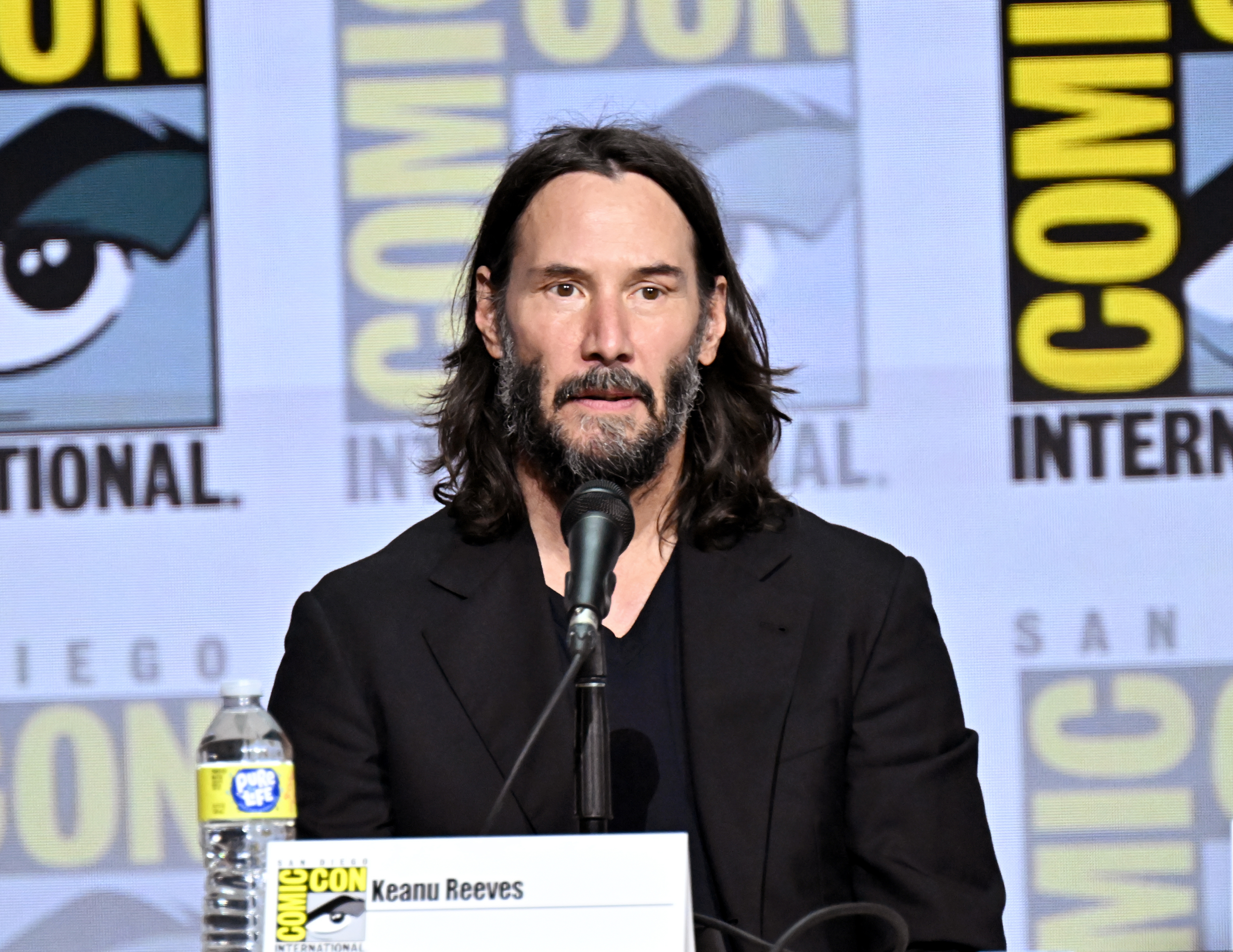 Close-up of Keanu onstage in front of a microphone