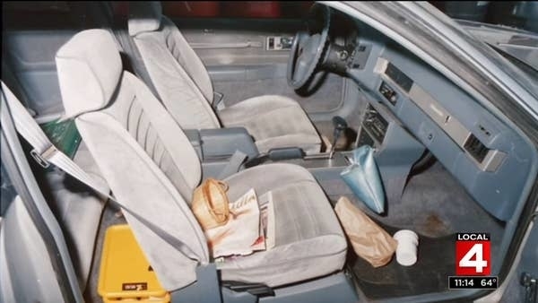 An empty car with trash in the passenger seat