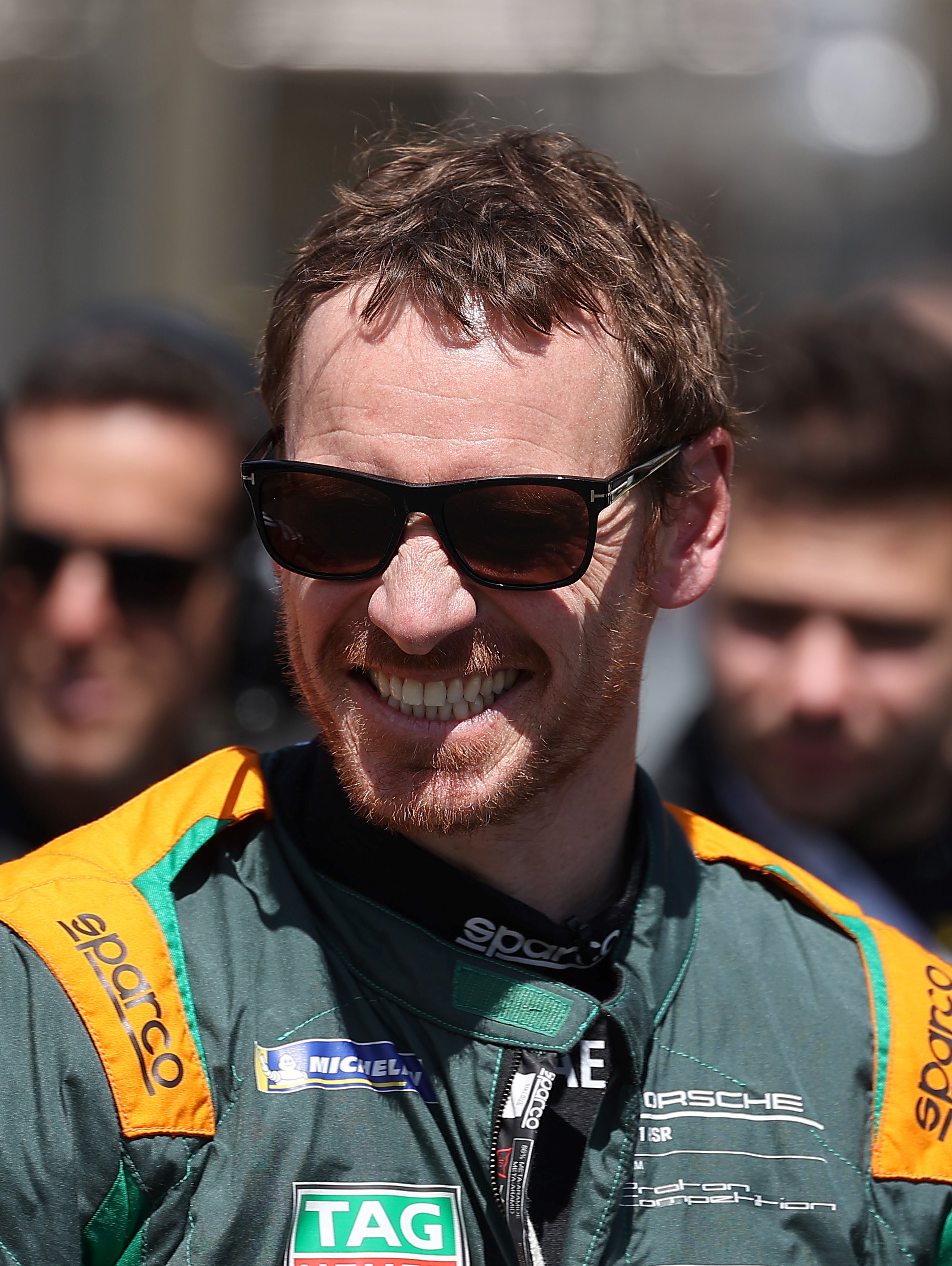 Close-up of Michael smiling and wearing a uniform as a race car driver