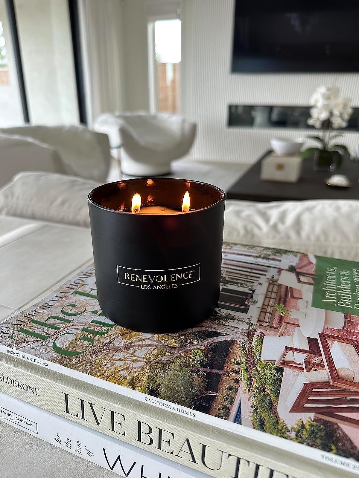 Reviewer image of the candle on a stack of coffee table books