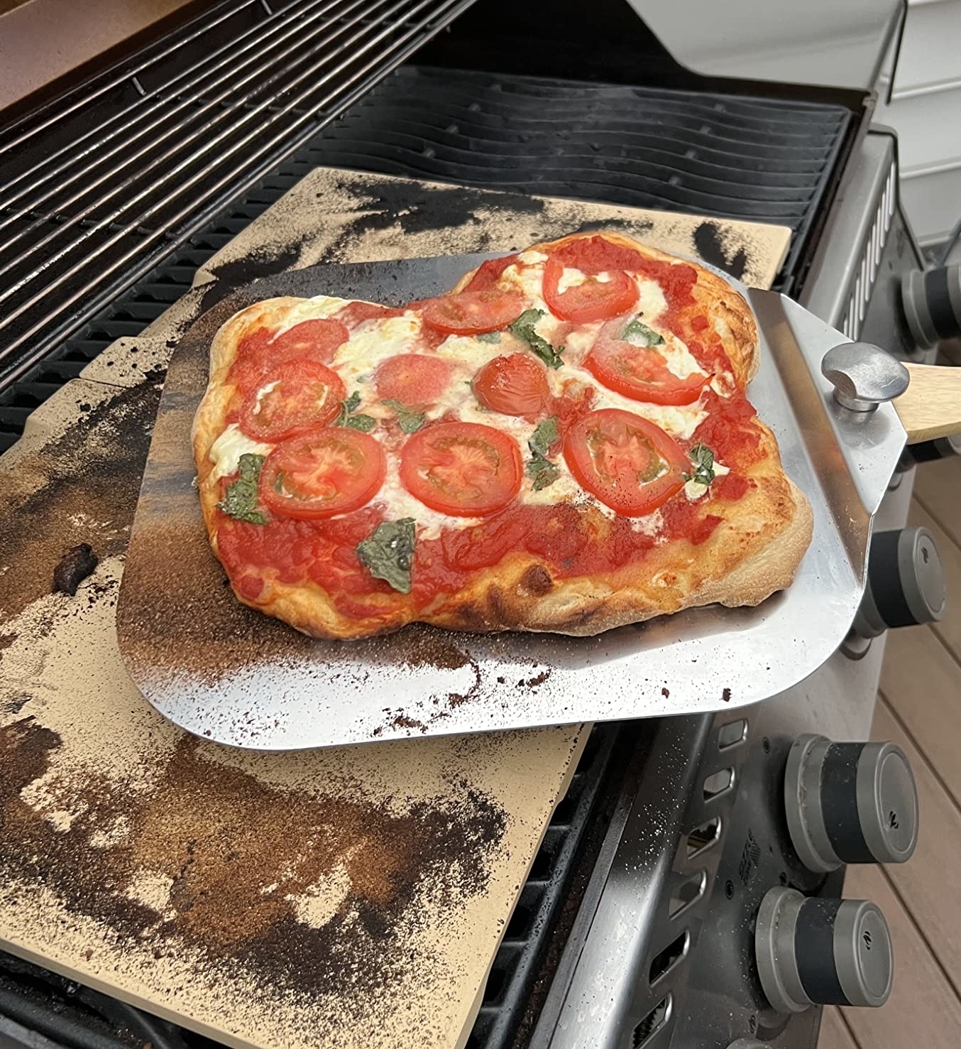 Reviewer image of pizza on the peel on a grill