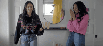 A gif of Lizzy playfully pushing Jessica on Honest Renovations