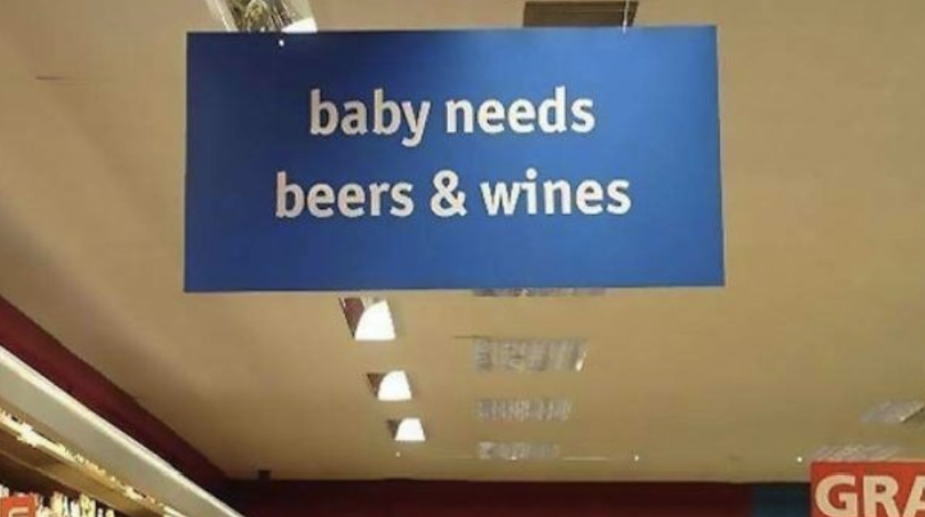 grocery store sign reads, baby needs beers and wines