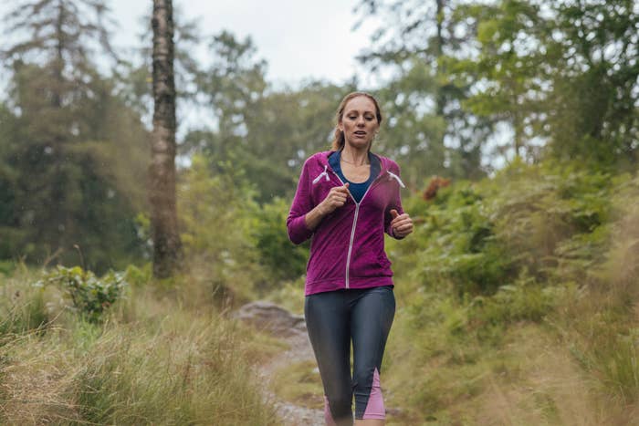 a woman jogging in the forest