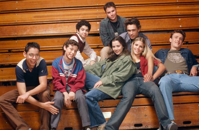 The cast of Freaks and Geeks sitting on school indoor bleachers