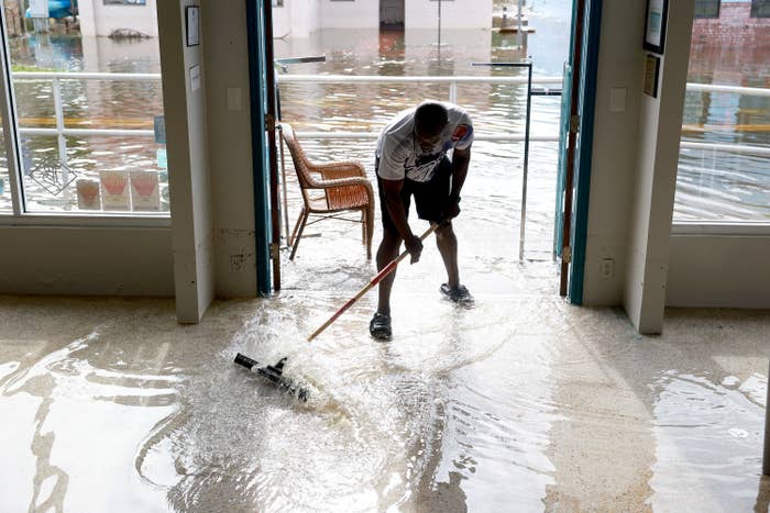A man sweeping away floodwater
