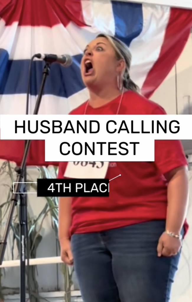 A woman standing at microphone and participating in the &quot;Husband Calling Contest&quot;
