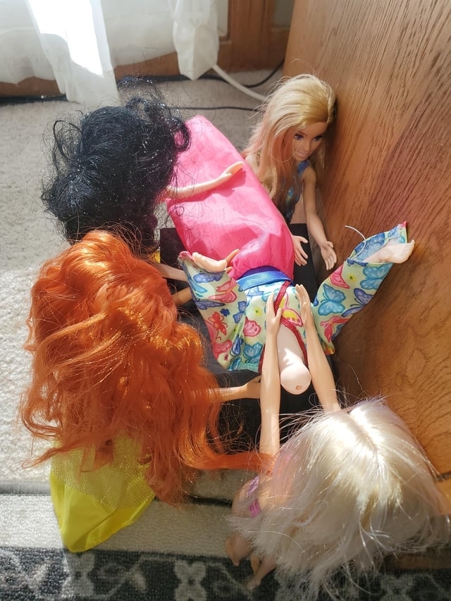 Barbies arranged to seem like they&#x27;re ganging up on one Barbie