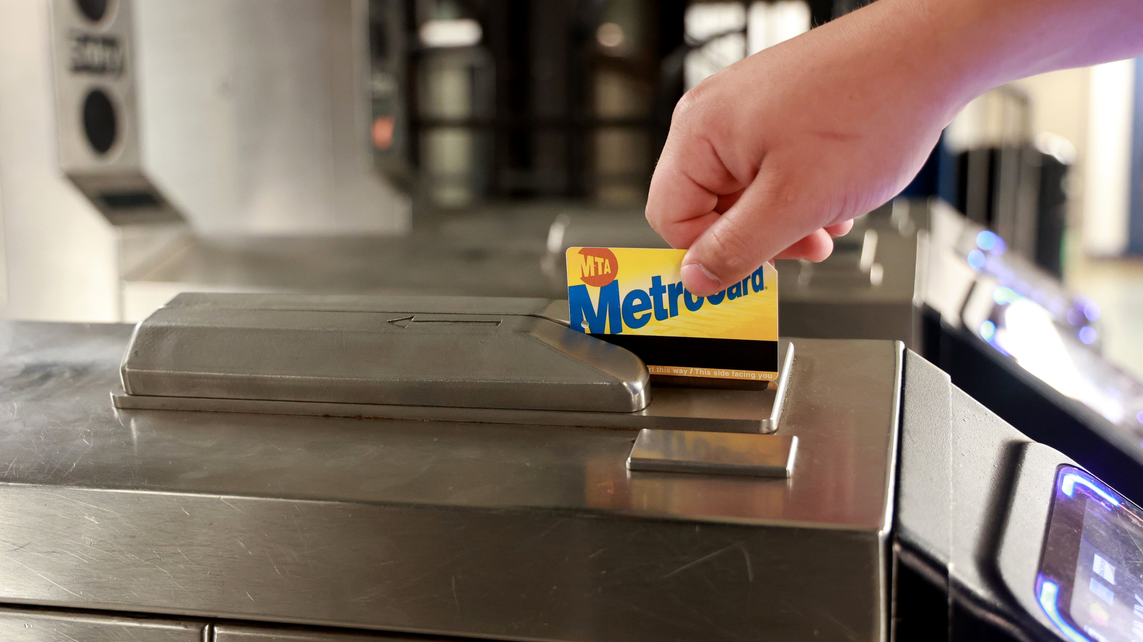 person swiping their metrocard to get on the subway