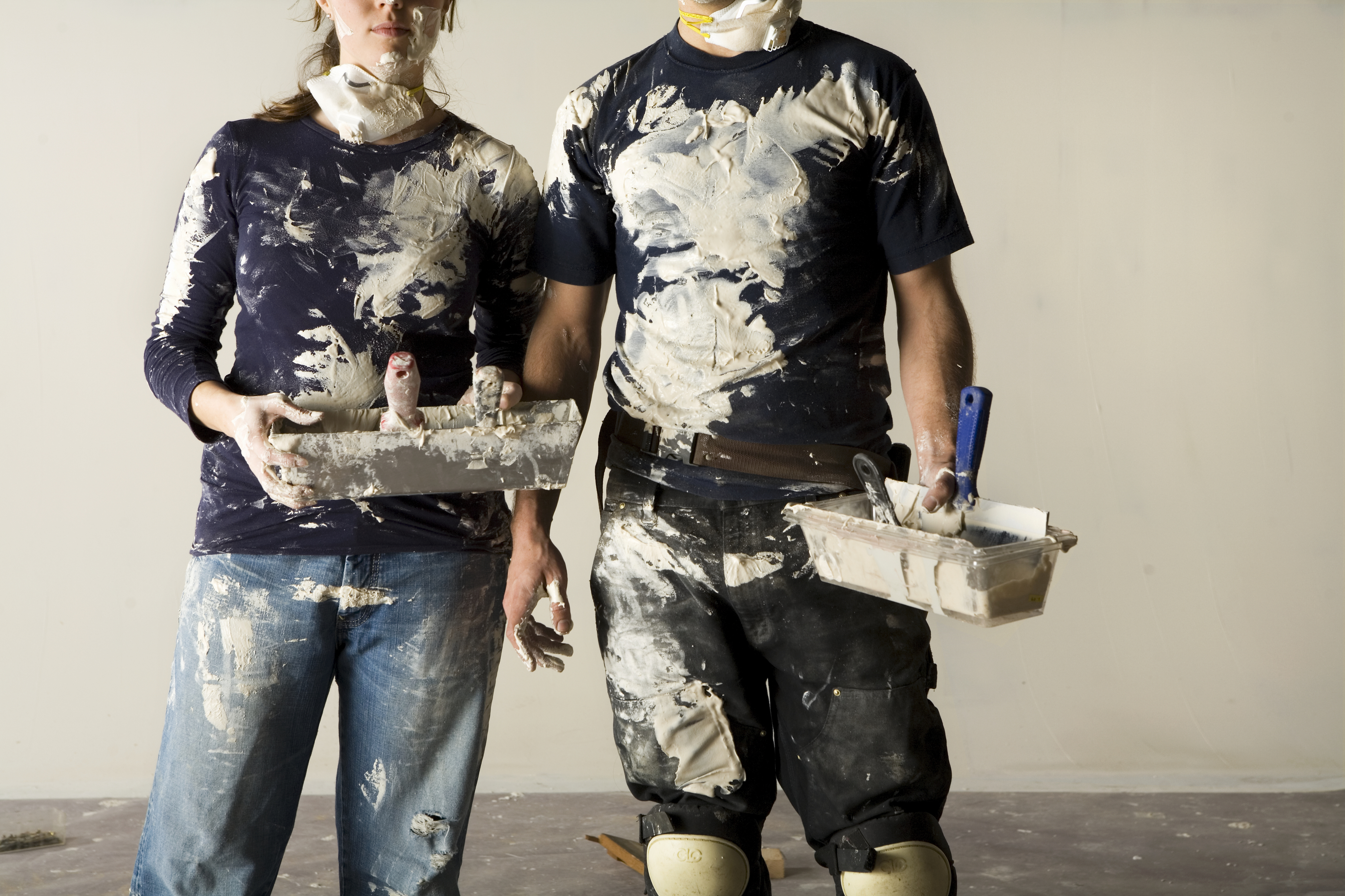 couple covered in paint after an attempted DIY project