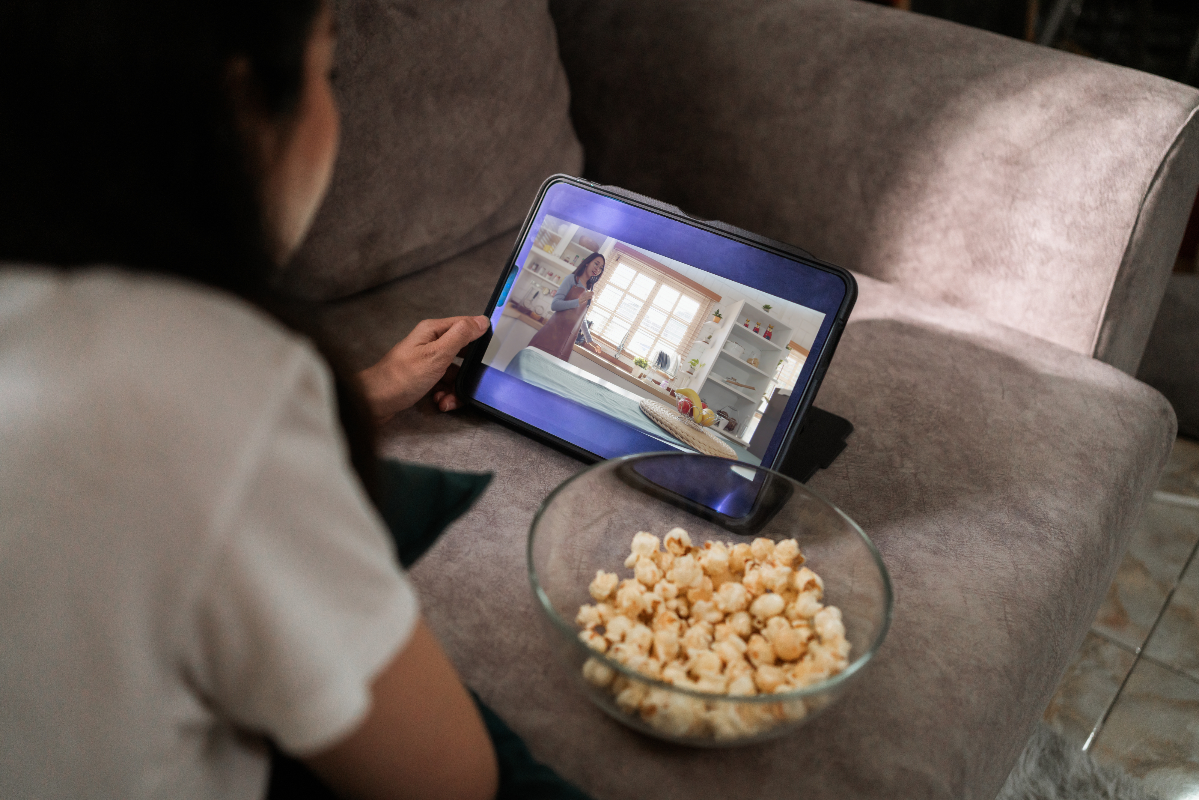 woman streaming tv on a tablet