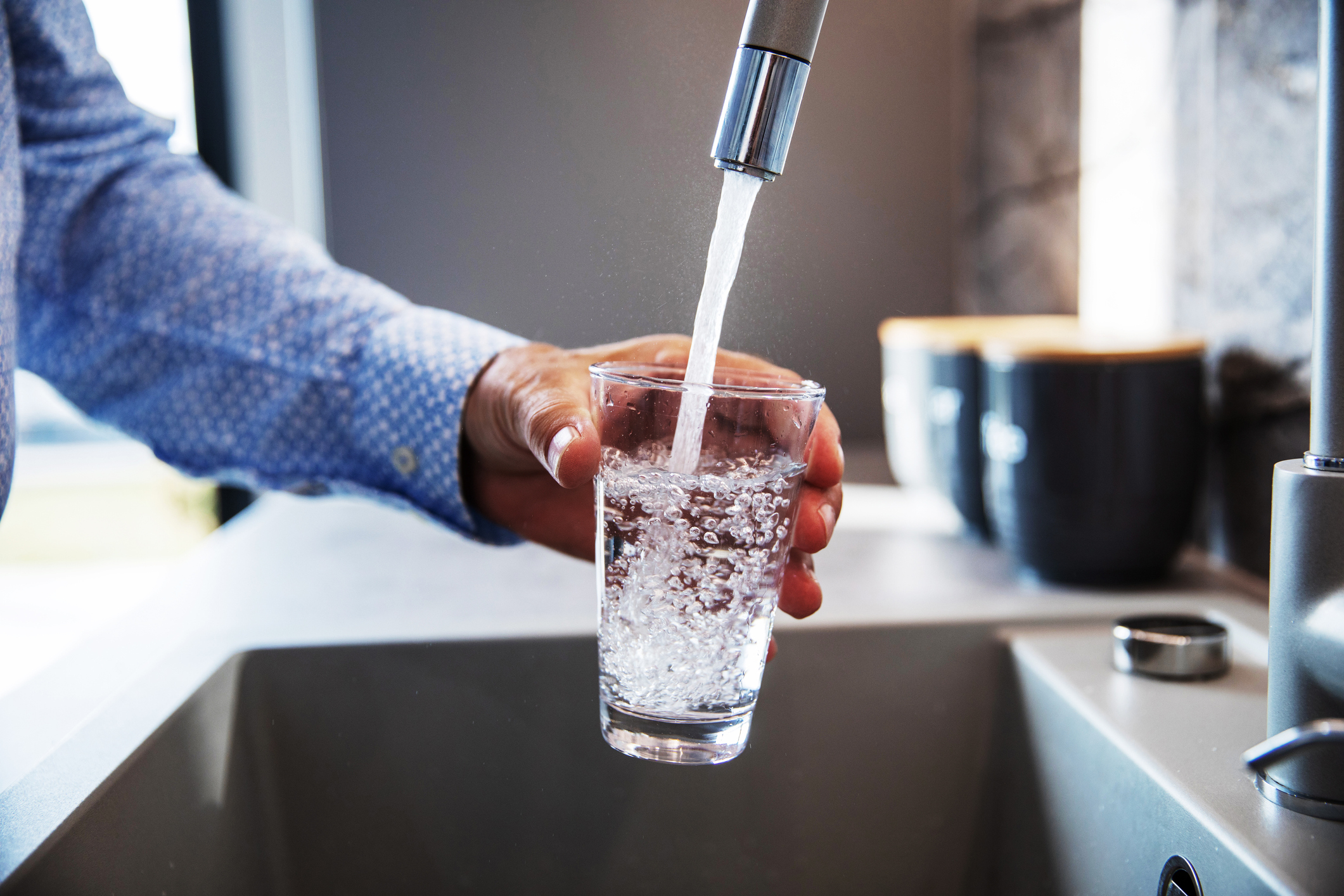 person getting water from the tap