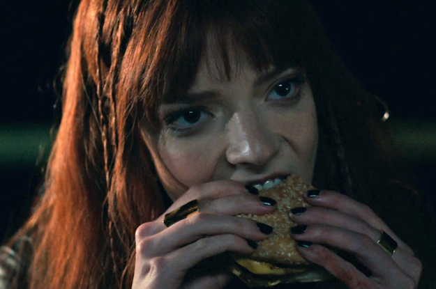 Anya Taylor-Joy eating a burger as Margot in The Menu