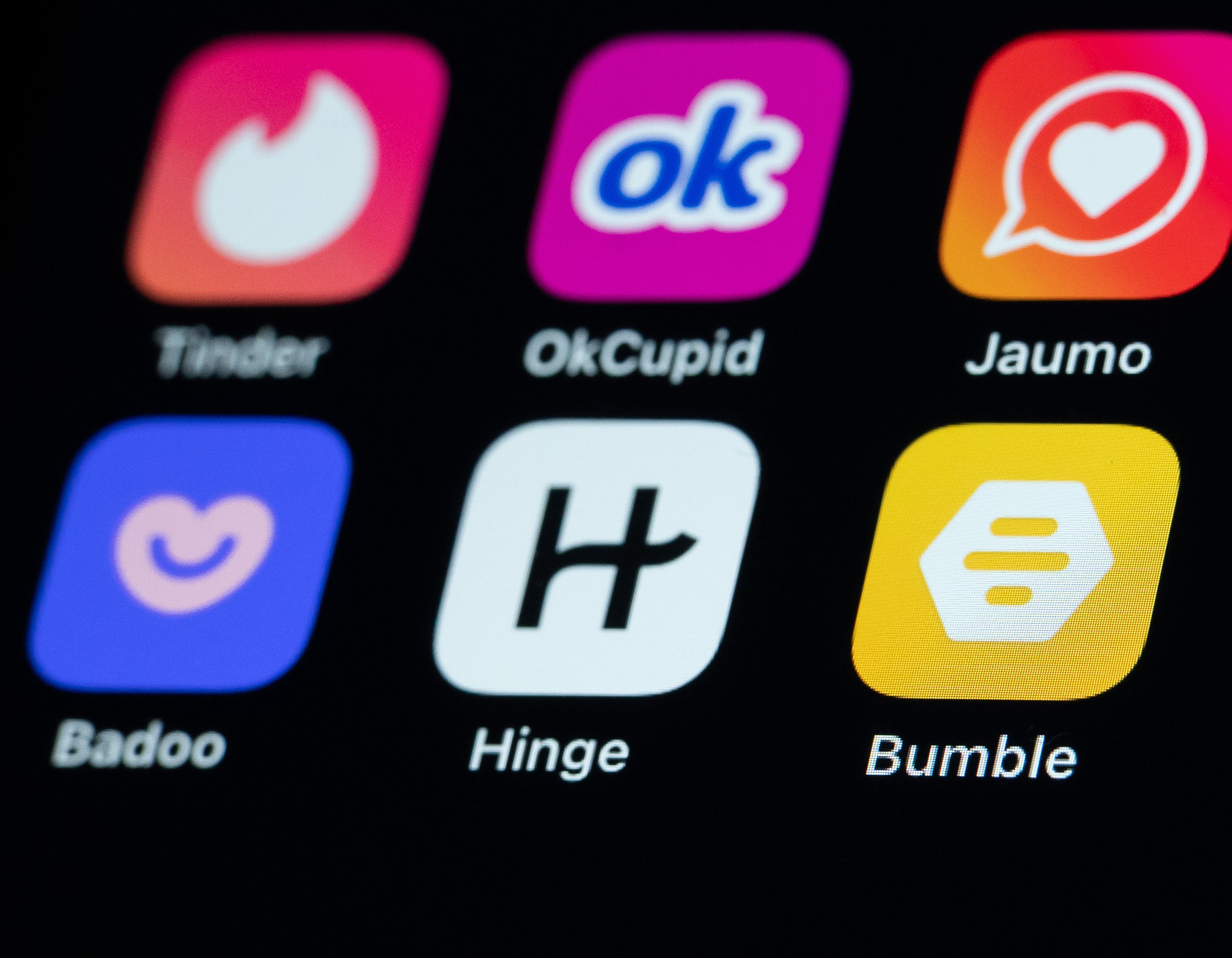 Phone screen displaying numerous dating apps, including Hinge, Bumble, and Tinder
